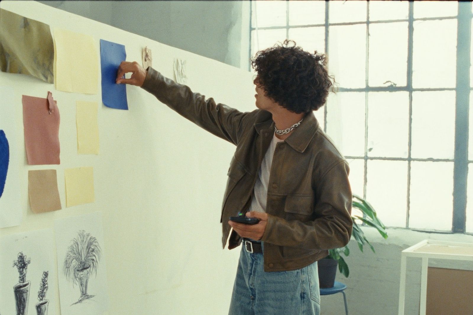 Creative pinning a cobalt swatch to a mood board in a loft studio